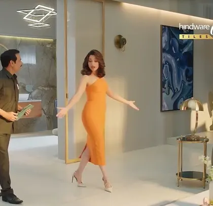 A wider shot showing Tamannaah giving a tour of the house in the Hindware commercial. Her dress adds a splash of color and glamour to the frame.
