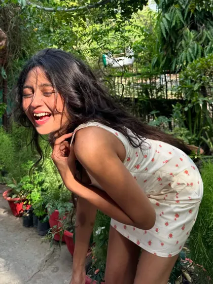 Doubled over in laughter in a lush garden setting. We don't take ourselves too seriously and always find reasons to smile.