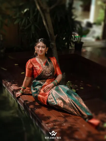 A serene portrait of the bride sitting by a pond. The natural setting and her calm expression create a peaceful and beautiful image.