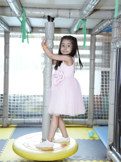 A young guest having a blast on one of our spinning play structures. Our play area includes a variety of equipment to help kids develop balance and coordination while having fun.