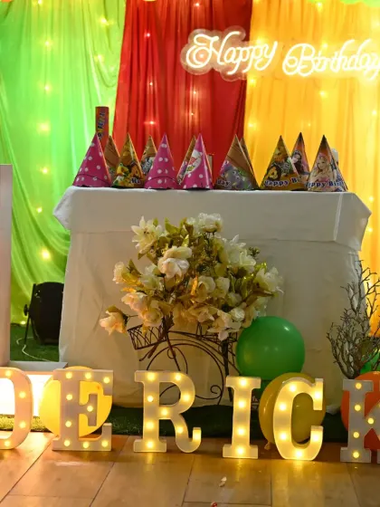 The birthday boy's name, Derick, in large marquee letters, placed in front of the cake table at his jungle-themed first birthday party.
