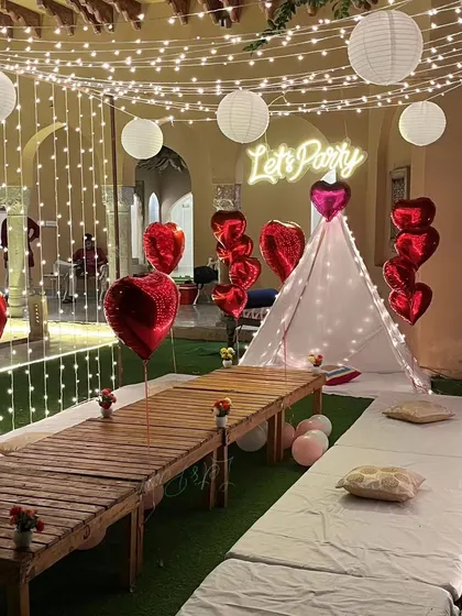 Another perspective of the garden party cabana, highlighting the combination of fairy lights and paper lanterns. The low wooden table and floor seating are ready for guests to enjoy a unique dining experience.