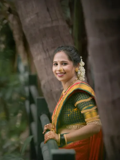 A lovely portrait by a wooden fence during the Vat Purnima shoot. The natural setting and her happy expression create a warm and authentic photograph celebrating the occasion.