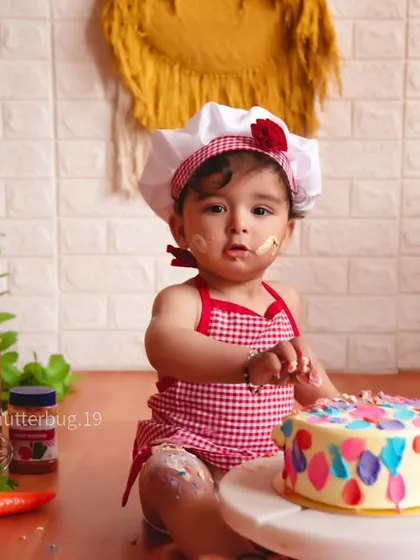 A sweet moment before the smashing begins, with our little chef curiously inspecting her first birthday cake.