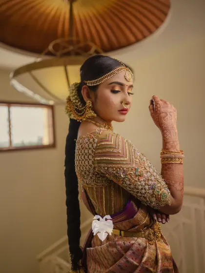 A stunning shot of Priya, her gold blouse and intricate hairstyle creating a look of timeless elegance.