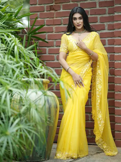 A vibrant yellow organza saree with delicate embroidery, perfect for a Haldi ceremony or a summer wedding.