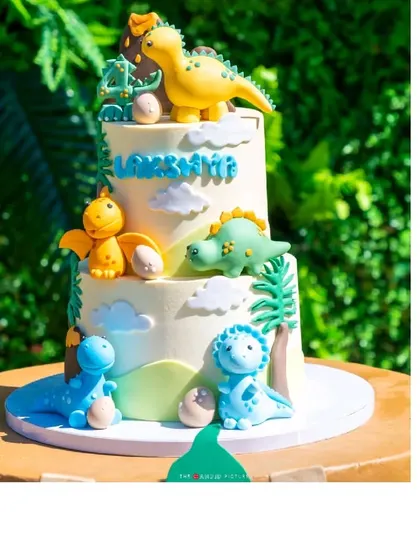 The adorable two-tiered dinosaur-themed birthday cake, adorned with cute, colorful fondant dinosaurs.