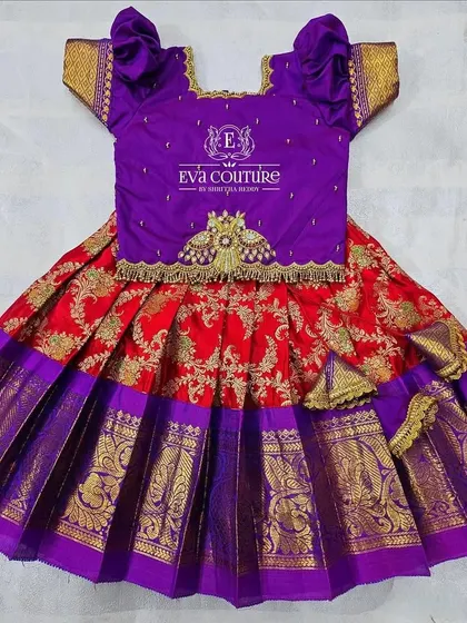 A rich combination of red and purple for this toddler pattu lehenga. The purple blouse has a lovely embroidered motif, and the red Banarasi skirt is bright and festive.