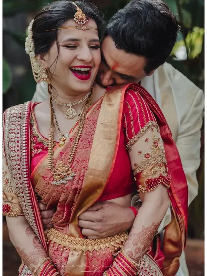 Capturing a moment of pure happiness. Our bride radiates joy in her custom-designed red silk saree and intricately embroidered blouse. It is my greatest honor to dress couples for the most cherished moments of their lives.