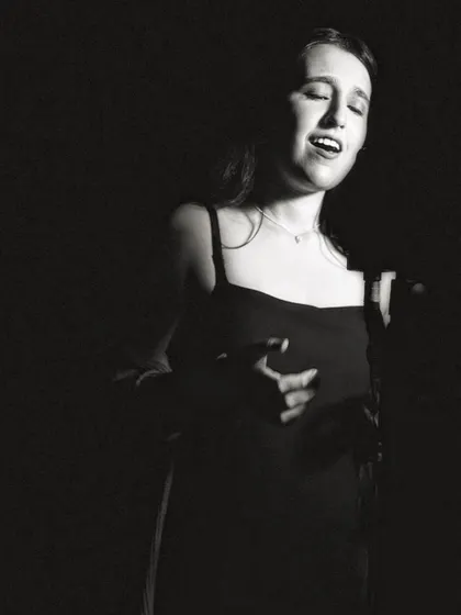 A classic singer's pose in black and white. This photo captures the essence of a vocalist lost in their song.