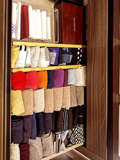 A beautifully organized sock and tie drawer. By rolling and arranging them neatly, you can quickly find the perfect accessory to complete your outfit without any hassle.