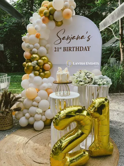 A full view of the elegant 21st birthday setup, complete with large foil number balloons.