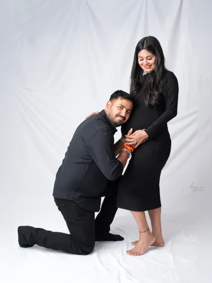 A classic pose full of love. The dad-to-be kneels to listen to the baby bump, a sweet and timeless moment to capture.