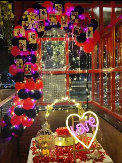This balcony setup is perfect for a romantic surprise with a view. I used a balloon arch personalized with photos, a "LOVE" neon sign, and a table covered in rose petals to create an intimate and memorable setting.