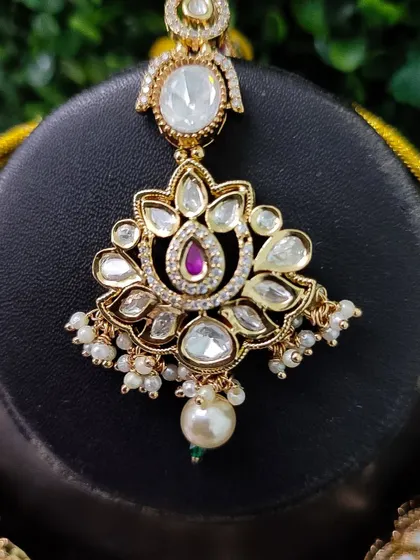 The maang tikka from this set, perfectly designed to match the pendant of the necklace.