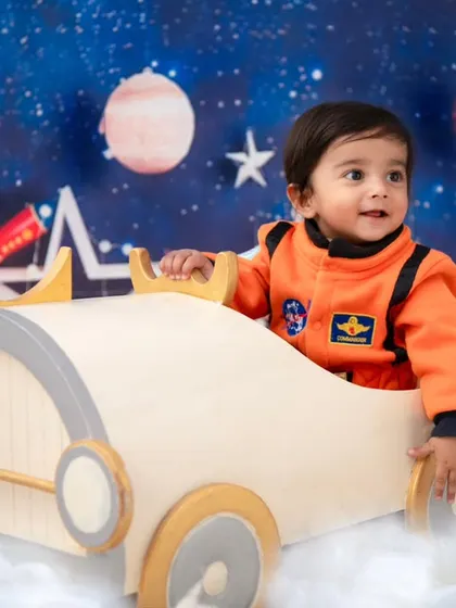 Ready for takeoff! This little explorer is at the helm of his spaceship, ready for an adventure among the planets and stars.
