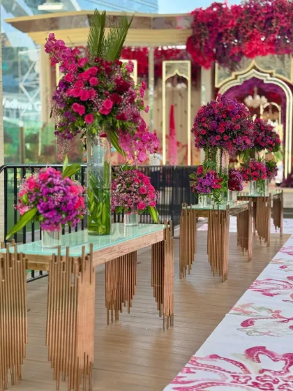 More views of the contemporary console tables adorned with large, vibrant floral arrangements, set against the backdrop of the city skyline.