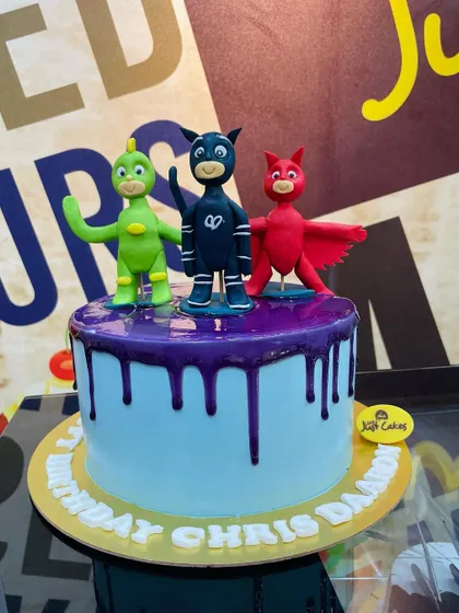 The PJ Masks heroes stand ready on this 2kg cake with a purple chocolate drip.