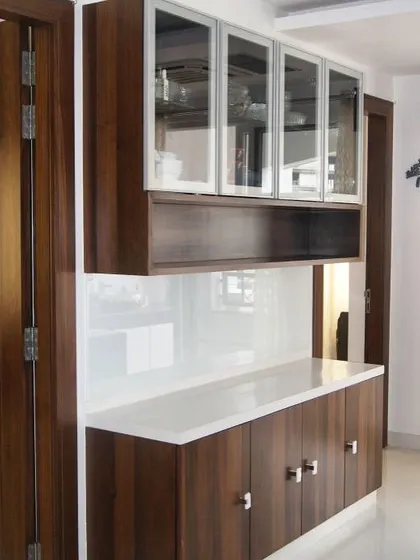 A classic crockery unit design with a wood finish and frosted glass doors. The open shelf in the middle is perfect for keeping frequently used items handy.