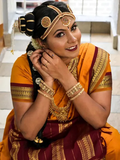 Adjusting the final details for this Brahmin bride. Her makeup is paired with a traditional hairstyle and a vibrant 9-yard saree, creating a look that is both authentic and stunning.