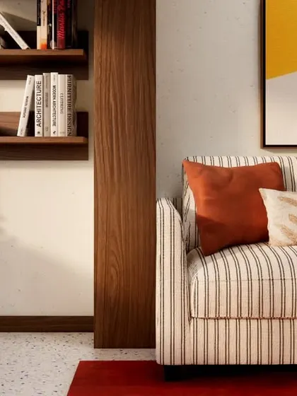 A close-up of the seating area in HAUS 5, highlighting the mix of textures from the striped sofa, plush cushions, and the smooth terrazzo floor.