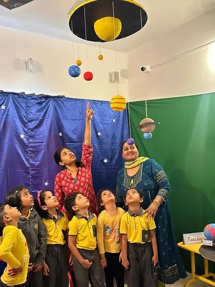 Children gaze up at a model of the solar system, learning about the planets and their orbits. We aim to inspire a sense of awe and wonder about the cosmos.