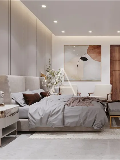 Here, a floor-to-ceiling upholstered headboard with vertical paneling adds texture and a sense of height to the room. The metallic accents on the side tables and lamps bring a touch of glamour.