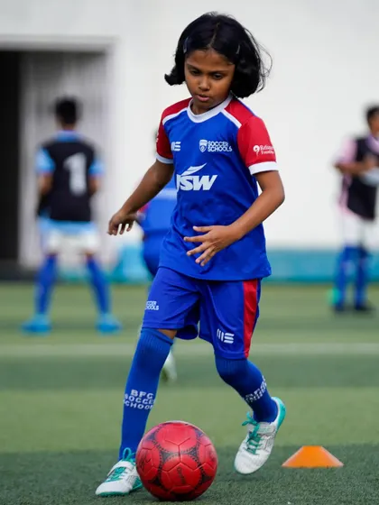 A young girl dribbles with determination. We provide equal opportunities and top-level coaching for all aspiring footballers.