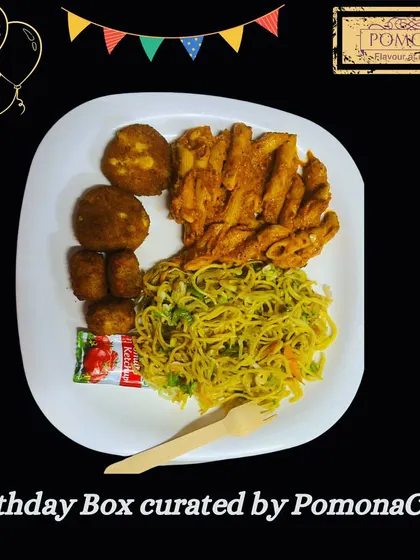 A sample birthday party meal, plated to show a delicious combination of hakka noodles, penne pasta, and vegetable cutlets. My birthday boxes are designed to be a complete, satisfying meal for guests of all ages.