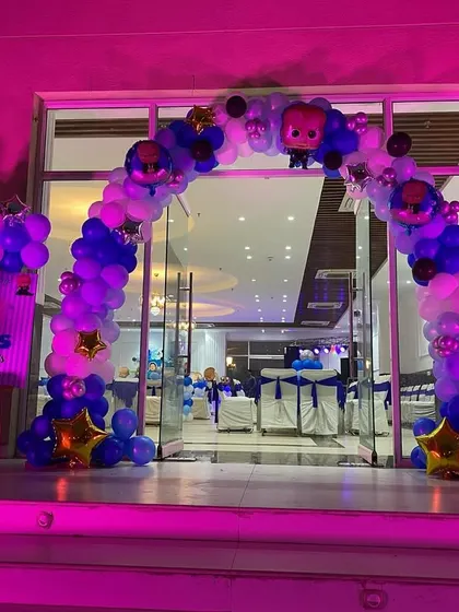 The entrance to a "Boss Baby" themed party, featuring a balloon arch and character cutouts to welcome the guests.
