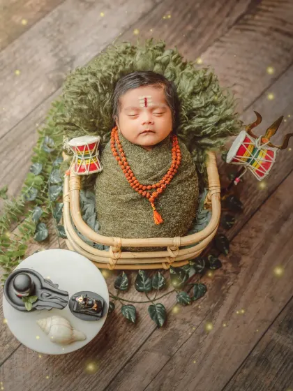 This 'Little Mahadev' theme includes symbolic props like the miniature Trishul, Damaru, and Shivling, all arranged safely around the sleeping baby.
