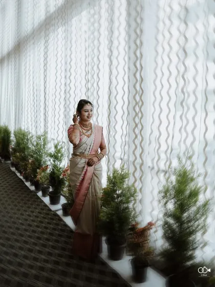 A full-length portrait of the bride standing in a long hallway, the repeating patterns of the curtains and plants creating a beautiful composition.