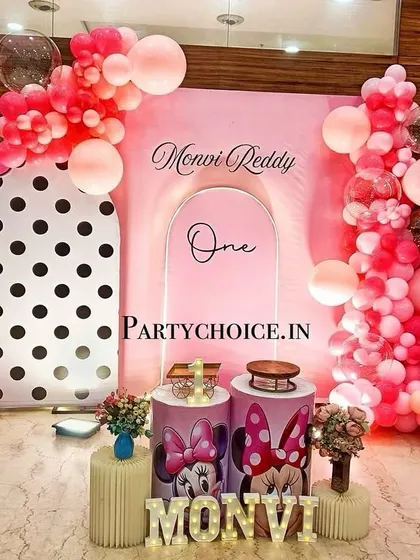 A modern and chic Minnie Mouse theme for a first birthday. We used a combination of polka-dot and solid pink backdrops, creative balloon arrangements, and light-up letters for a stylish celebration.