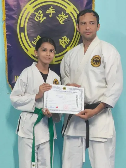 Awarding a 4th Kyu (green belt) certificate to a student who has shown great perseverance. Her progress in both kata and kumite has been impressive.