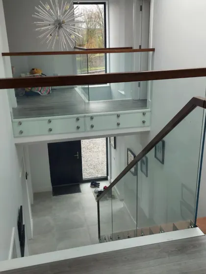 A complete view of the finished project, showing the staircase, the upper landing balustrade, and how it fits into the home's entrance hall.