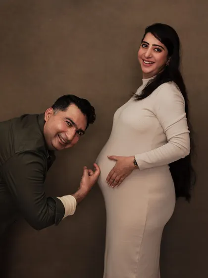 A playful and sweet moment during a fine art maternity shoot, with the dad-to-be listening to the baby bump.