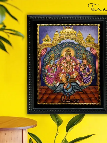 This exquisite Tanjore painting depicts Lord Murugan with his consorts, Valli and Devayani. The artwork, rich in gold foil and color, symbolizes divine love, harmony, and strength.