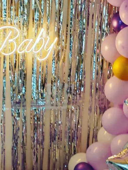 Detail of the neon sign and the silver shimmer backdrop, which catches the light beautifully and adds a touch of glamour to the celebration.