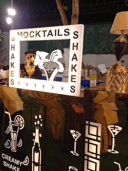 A fun and quirky mocktail and shake bar designed for a lively celebration. The custom-designed counter with graphic cutouts and decorative lamps creates an inviting spot for guests to grab a refreshing drink.