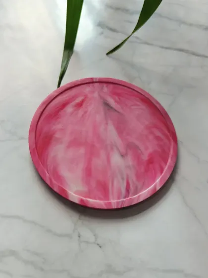 A vibrant pink and white marbled coaster that adds a pop of color to any setting. These are perfect for festive gifting or as a cheerful addition to your workspace.