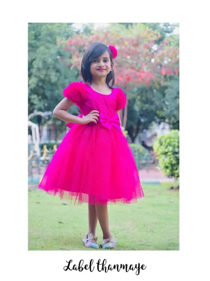 This bright pink "Barbie" frock is a popular choice for birthdays. It has cute puffed sleeves and a big bow at the waist.