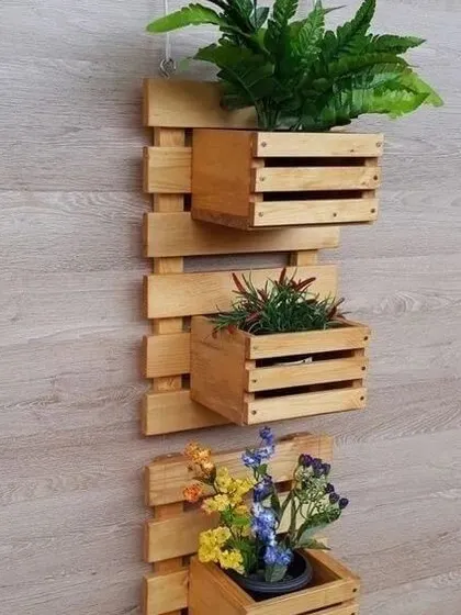 A simple yet elegant wall-mounted planter made from pinewood. This three-box design is ideal for creating a small herb garden or displaying colorful flowers in a compact area.