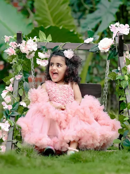 A beautiful, happy smile from a little princess on our floral swing. The lush green background makes the pink dress pop.