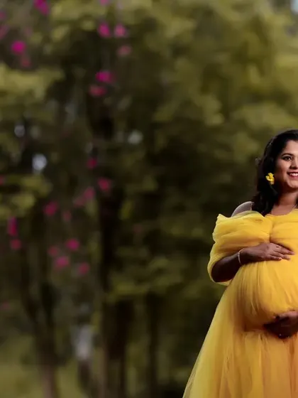 The long, flowing tail of the yellow maternity gown creates beautiful movement in photos, especially in an outdoor setting with a gentle breeze.