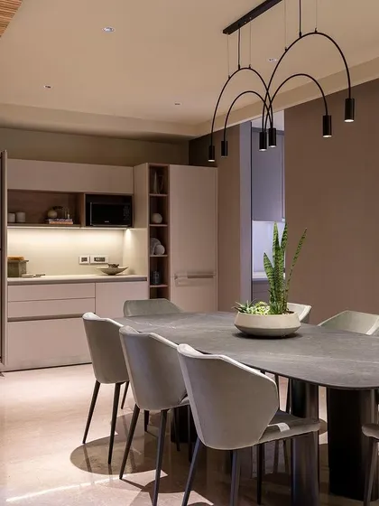 This concept for a modern dining area features a sleek kitchenette that can be concealed behind cabinet doors. The minimalist design and sophisticated color palette make it perfect for open-plan living.