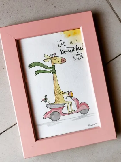 A whimsical watercolor illustration of a giraffe riding a scooter. This playful piece, framed in pink, is a fun reminder that 'Life is a Beautiful Ride'.