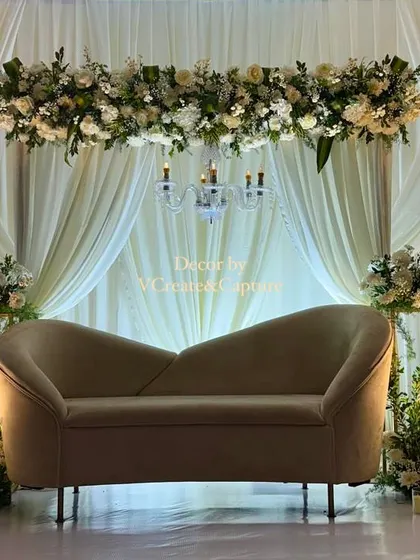A full view of the elegant off-white and green stage, perfect for an intimate engagement or reception.