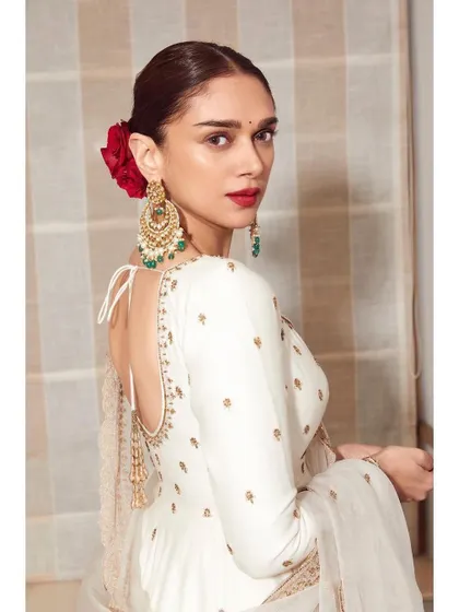 The back of this anarkali is just as stunning, with a deep back and beautiful tassels. We completed the look with a classic red rose in her hair for a touch of old-world romance.