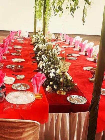 An elegant groom's table setup with floral centerpieces and hanging decorations. We work with you to create a beautiful dining ambiance that complements your wedding decor.