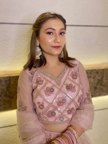A soft and pretty party makeup look for a client in a pink lehenga. The makeup features pink eyeshadow and a matching lip color.